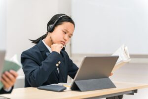 オンライン英会話を半年続けても効果を感じられず、頬杖をついて考え込む女性