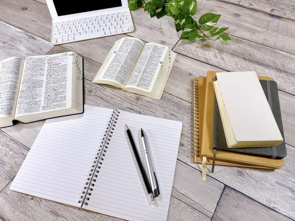英語の辞書とノートを広げたオンライン英会話の学習机