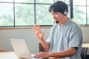 オンライン英会話で発音を練習しながらレッスンを受ける男性