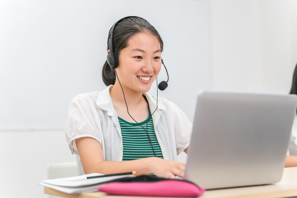 笑顔でオンライン英会話のレッスンを受ける女性
