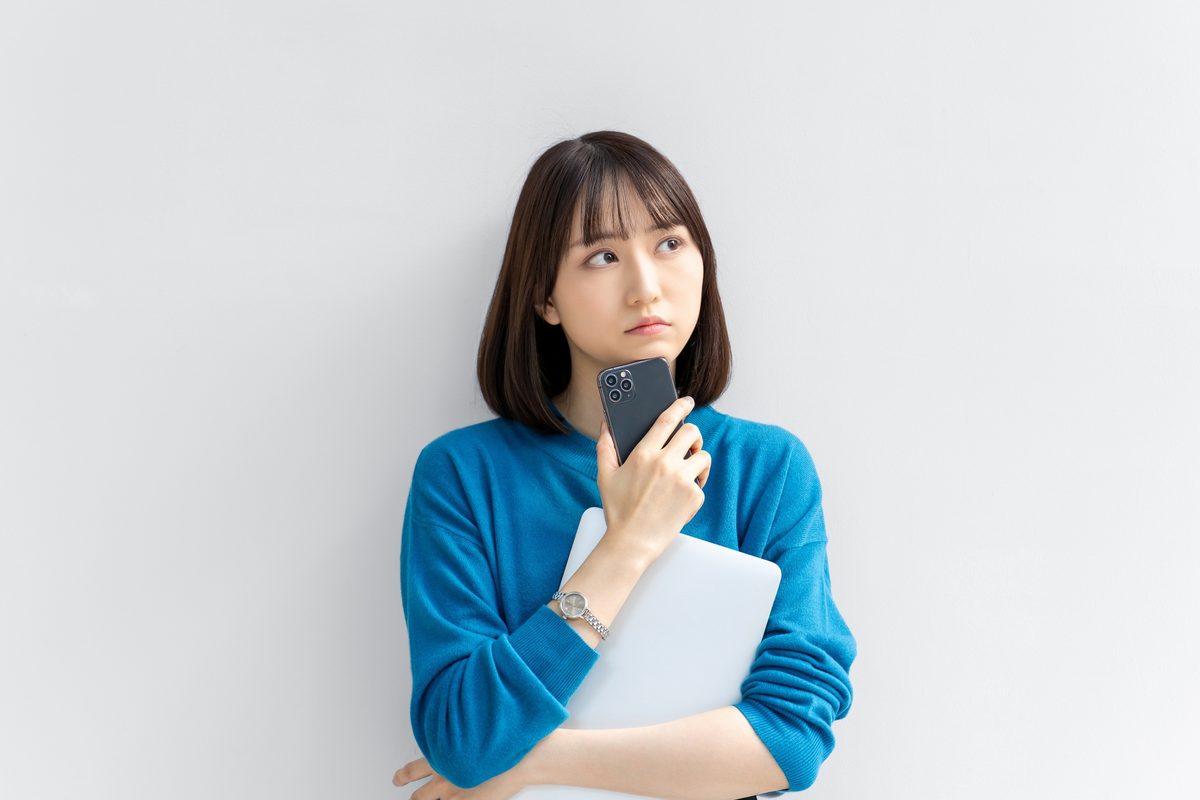 成果が出るまでの期間に不安を感じてスマートフォンを見つめる人