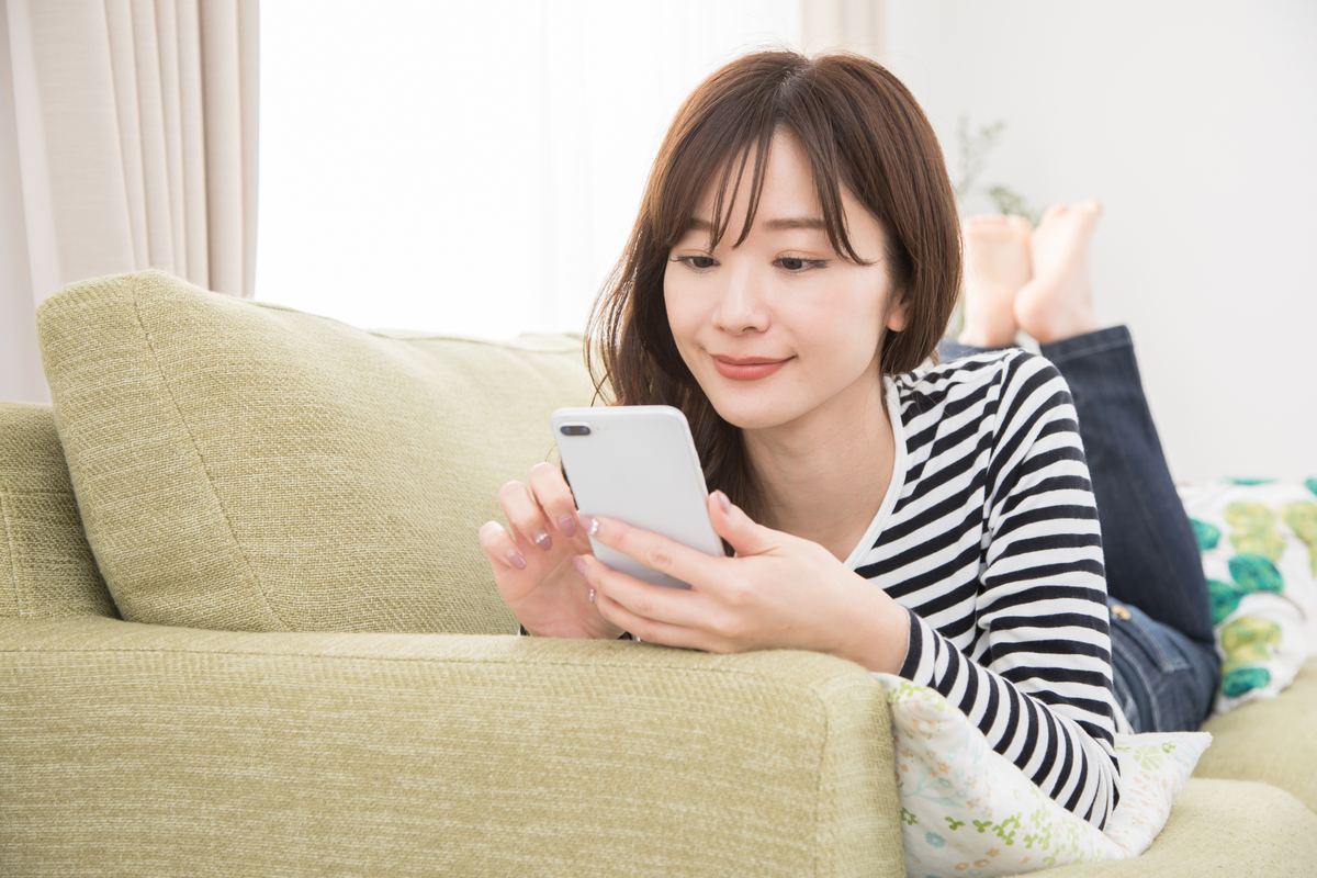スマートフォンで料金プランを確認する女性