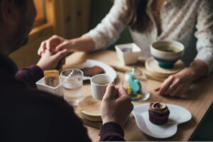 カフェで穏やかに会話する2人（オンライン英会話の怖さがほぐれるイメージ）