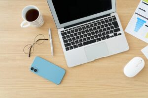 Claude Codeをやめるか続けるかを考えるノートパソコンとスマートフォンのある机